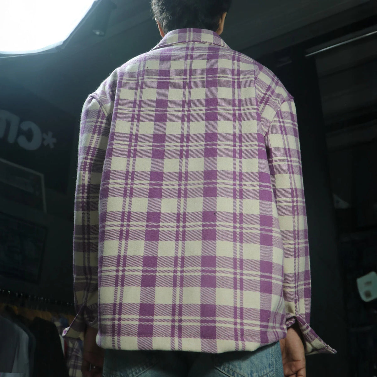 Plaid shirt shown from back, button-up long sleeves and spread collar