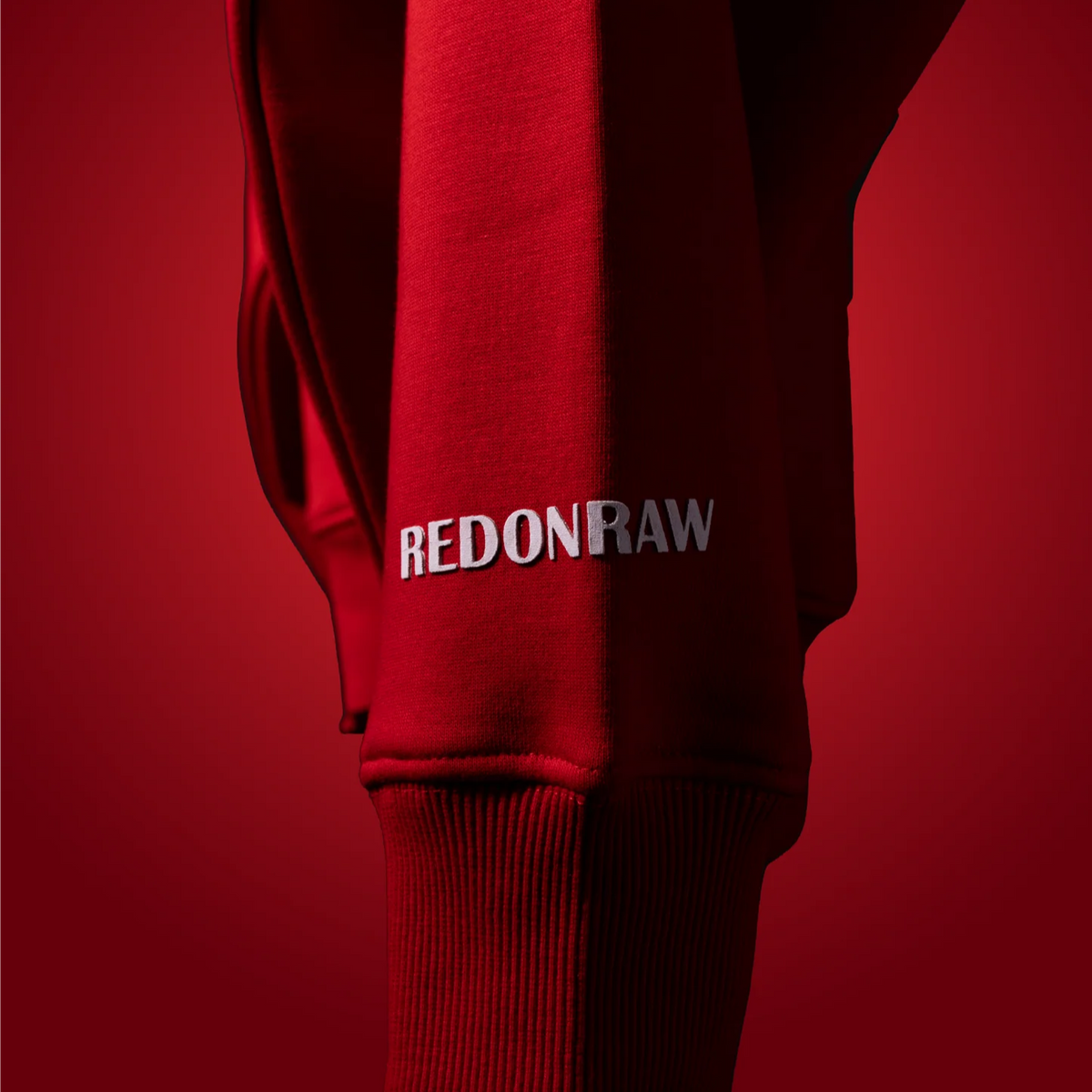 Blood red hoodie sleeve with REDONRAW logo print