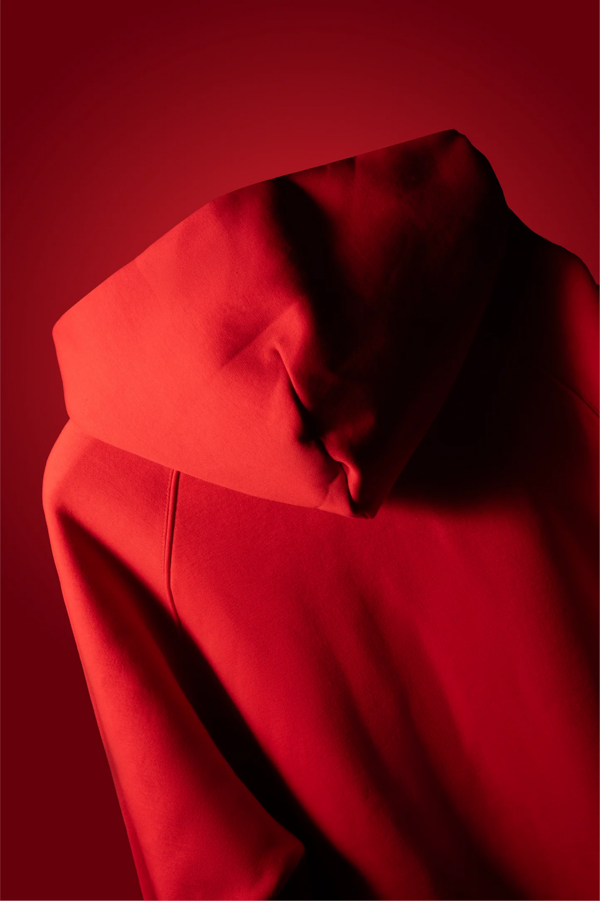 Blood red hoodie close-up with adjustable hood and draped neckline