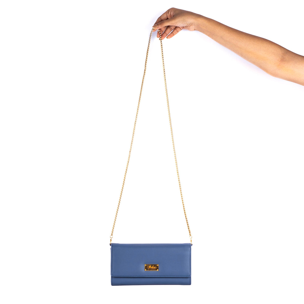 Blue crossbody clutch wallet with gold chain, held by hand