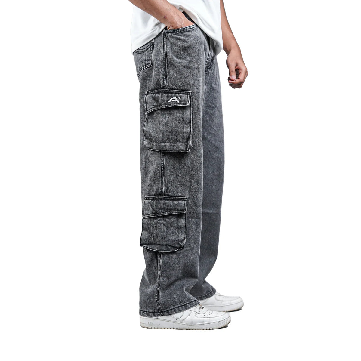 Grey denim cargo pants side view with flap cargo pockets and small logo patch