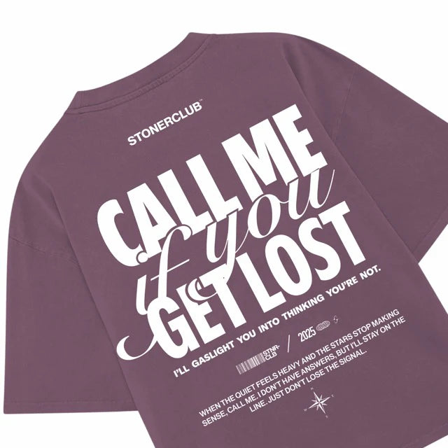 Purple graphic tee with 'CALL ME you GET LOST' print and small caption text