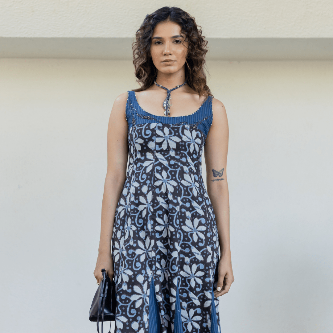 Blue sleeveless maxi dress with patterned bodice, scoop neckline, and tie-back strap detail