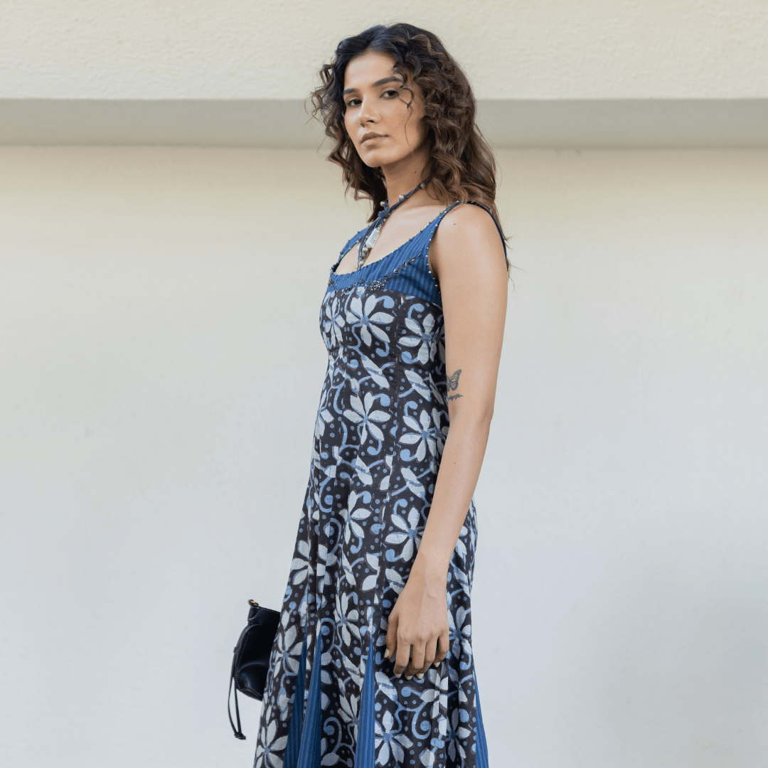 Blue sleeveless maxi dress with allover floral print, tiered hem, and long tie-neck detail