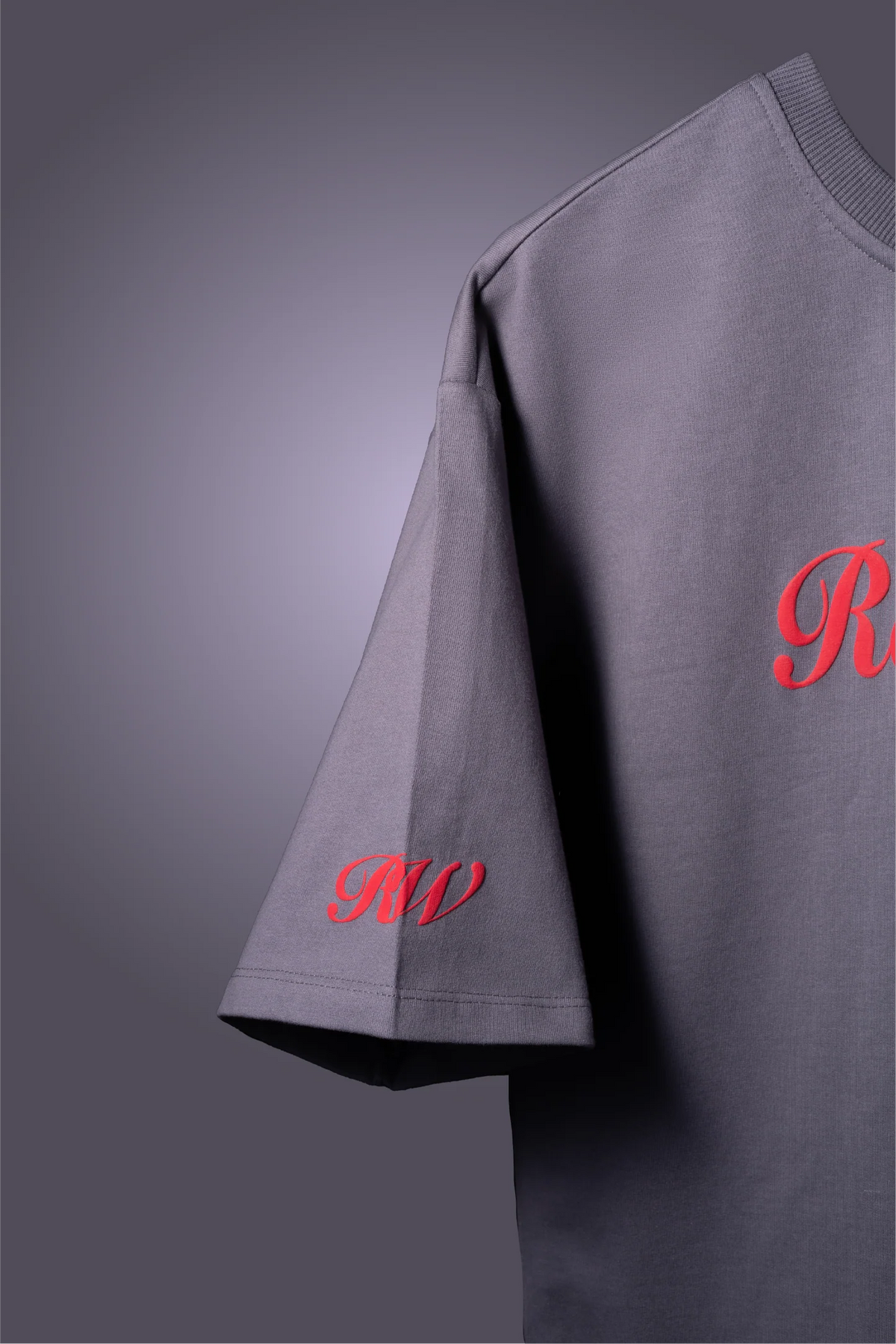 Gray T-shirt sleeve detail with red script 'Red...' and ribbed neckline