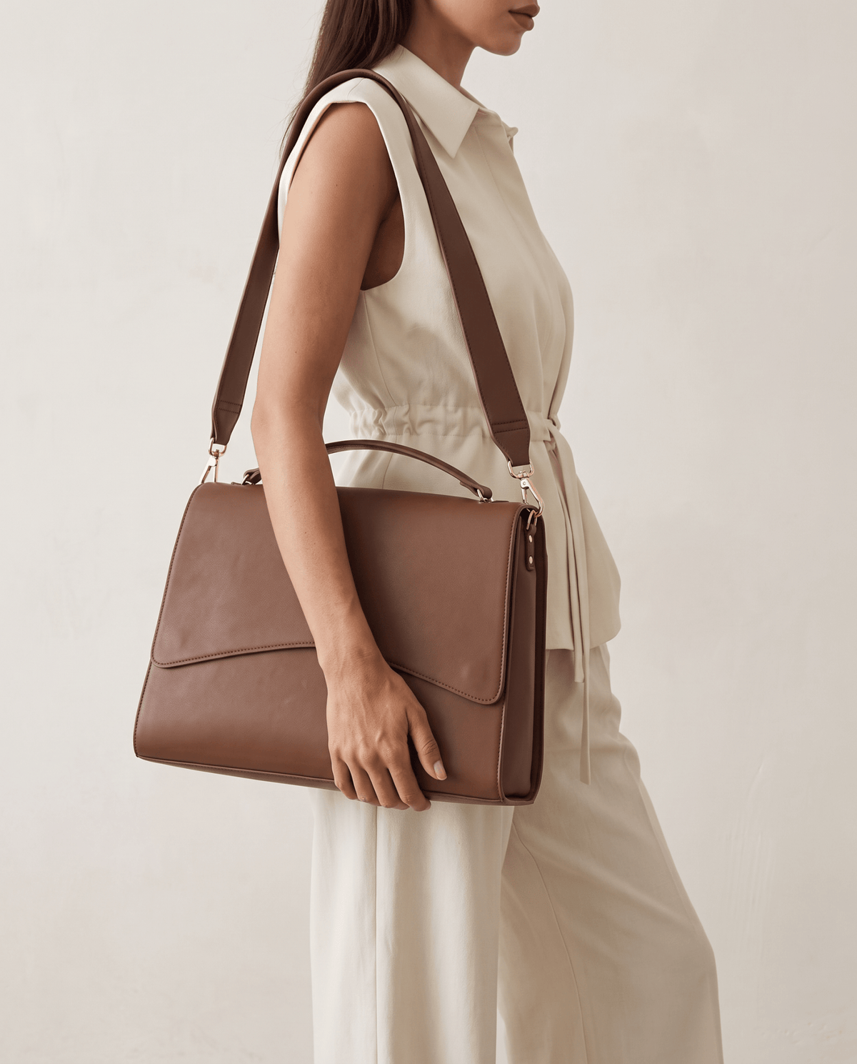 Light brown handbag worn on shoulder with top handle and flap front