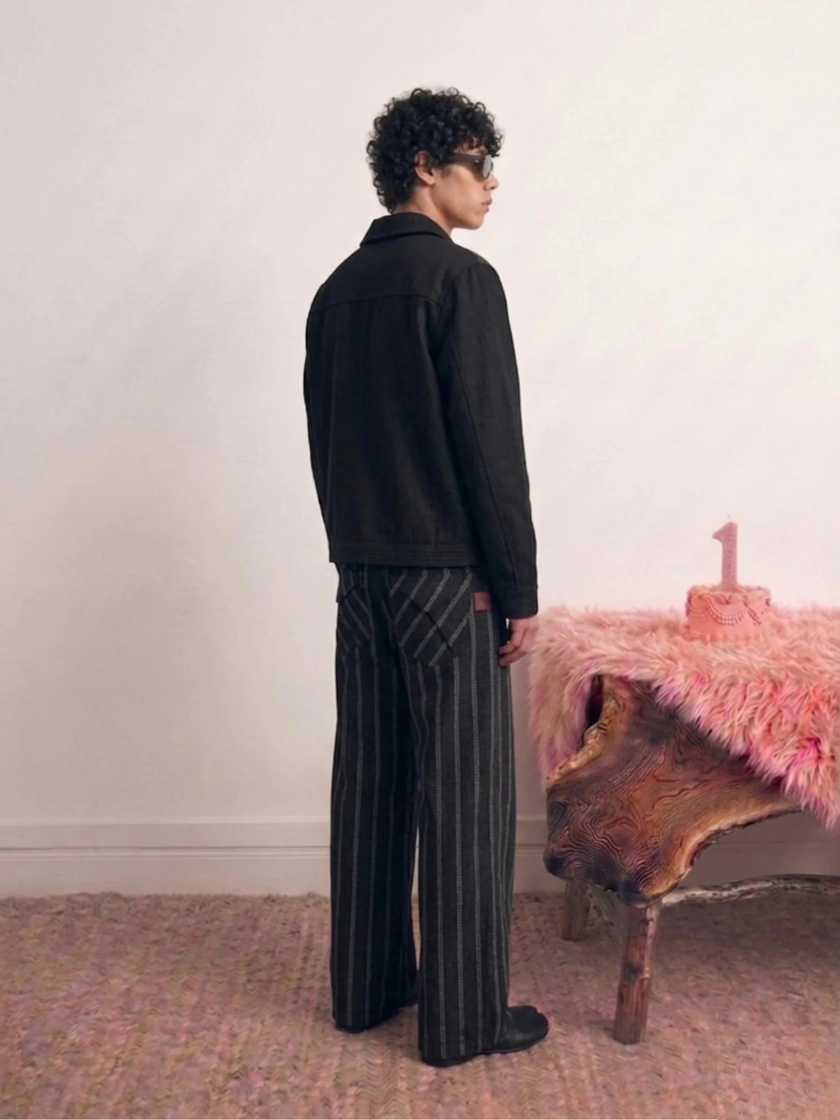 Black pinstripe jacket profile view with stand collar and button-front closure