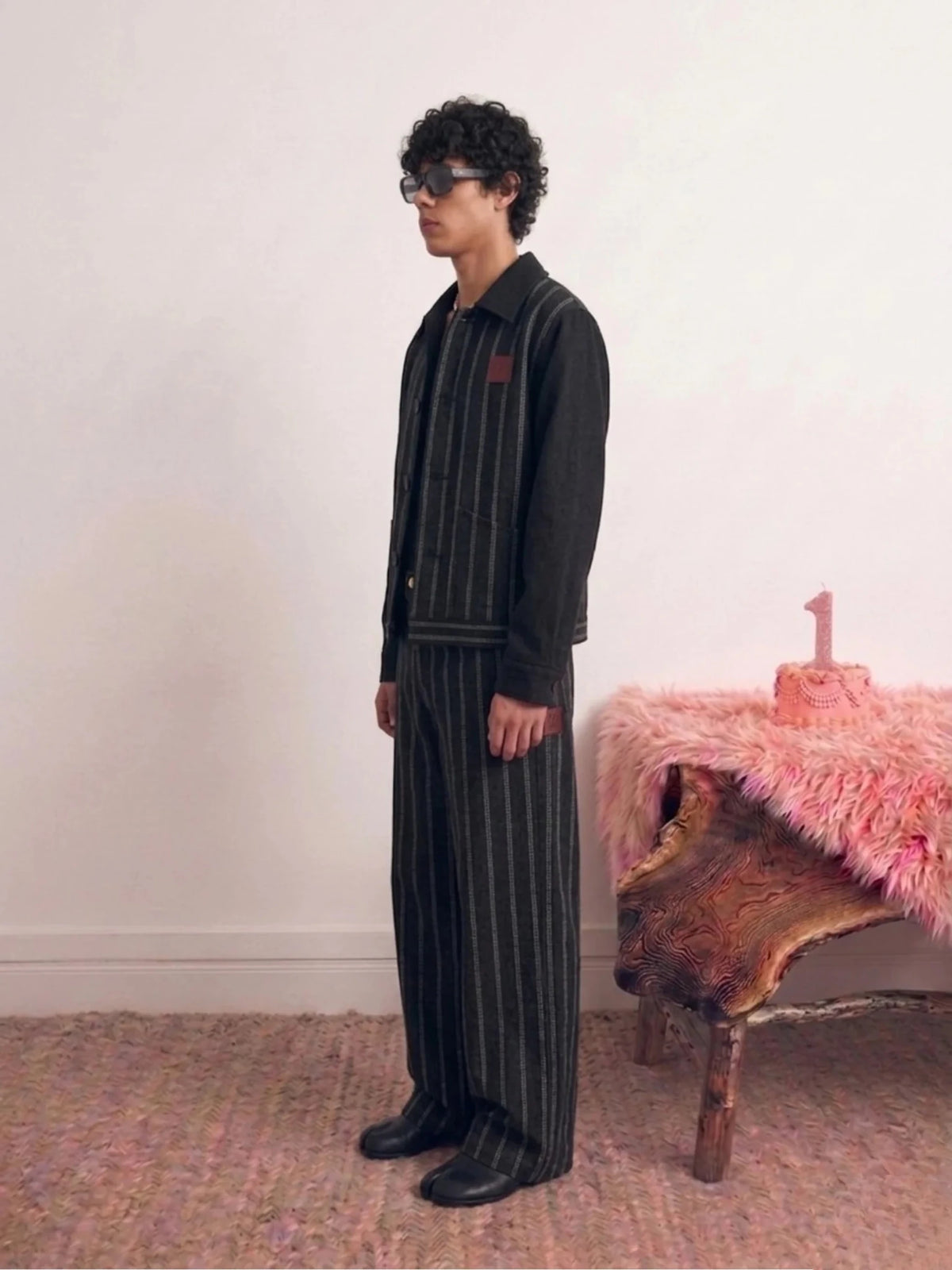 Black pinstripe jacket worn sideways with stand collar and button-front closure