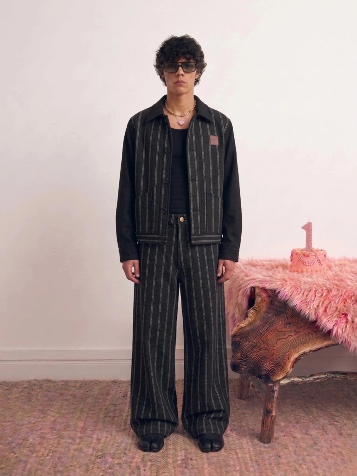 Black pinstripe jacket with stand collar, button front, and chest patch pocket