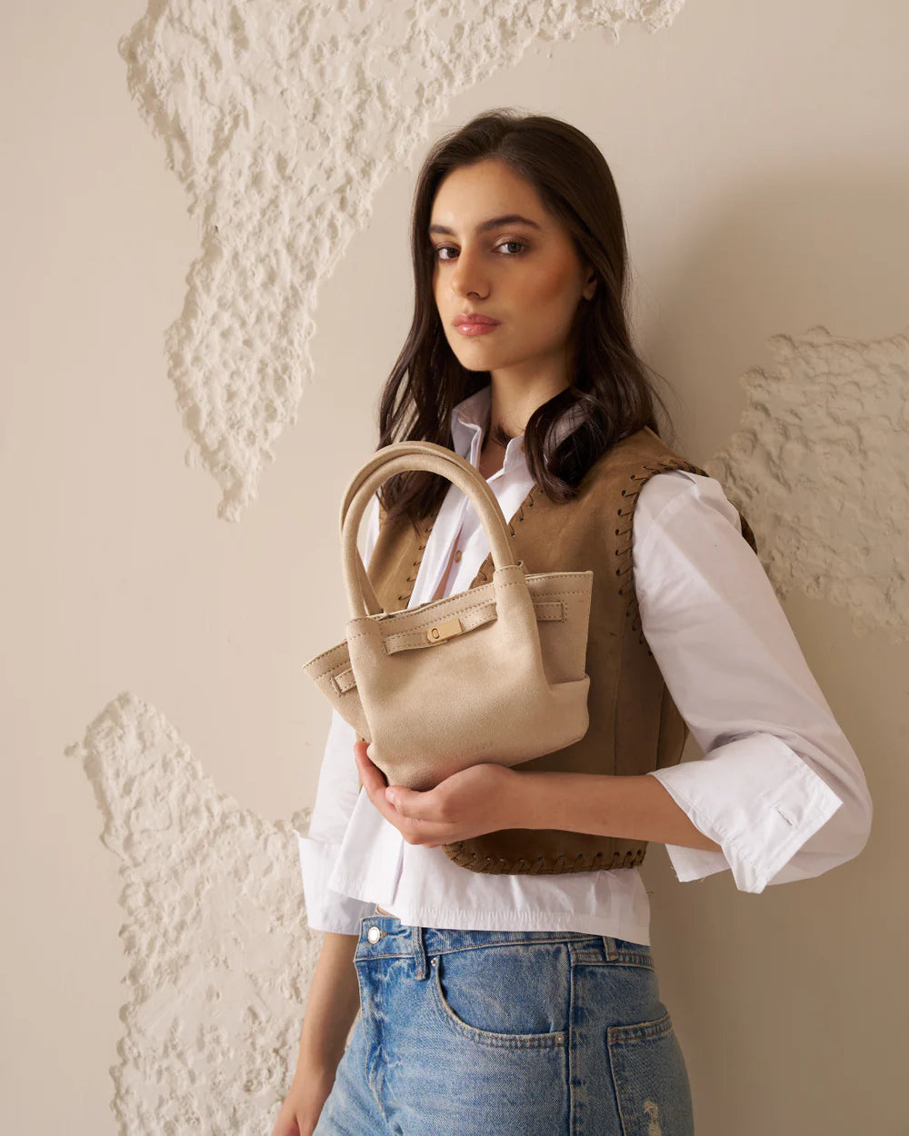 Cream mini tote bag with top handles and front strap buckle
