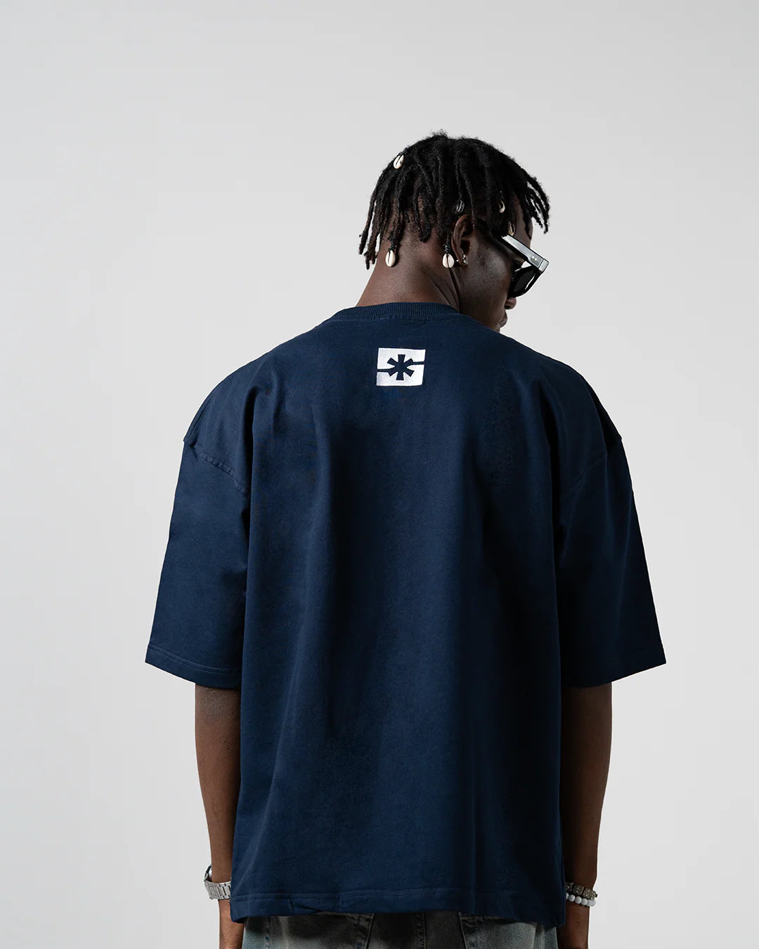 Dark blue crew-neck T-shirt with small square logo on upper back