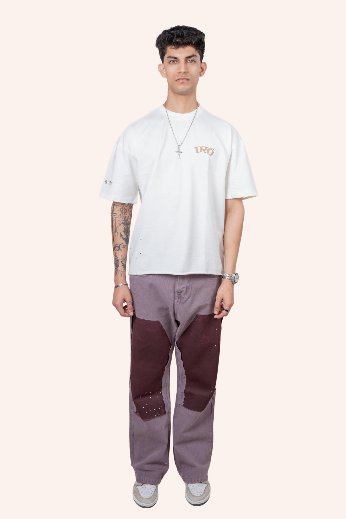 White crewneck T-shirt with small tan logo on chest and tan text graphic
