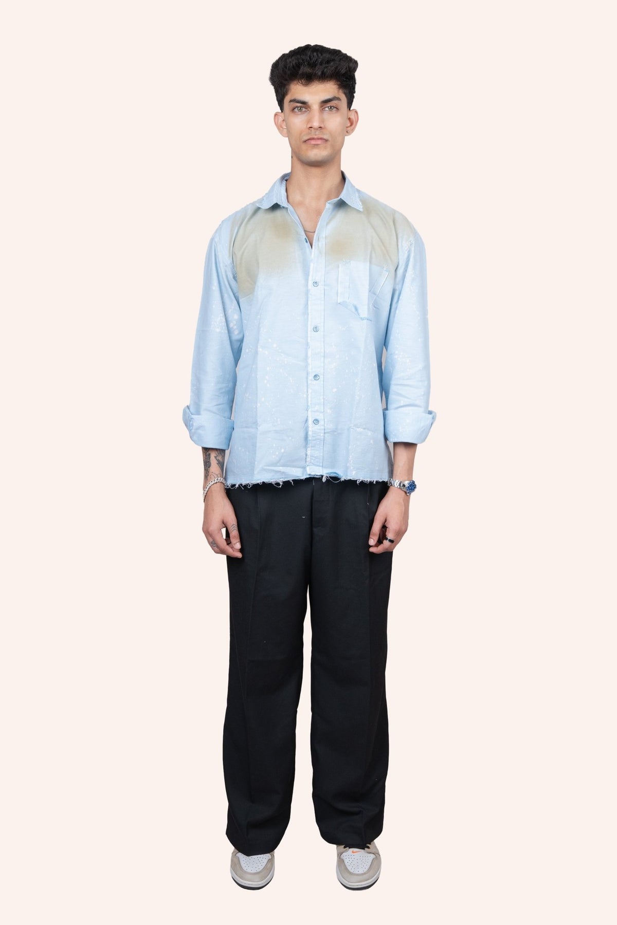 Light blue button-up shirt with distressed hem and speckled stain effect, chest pocket