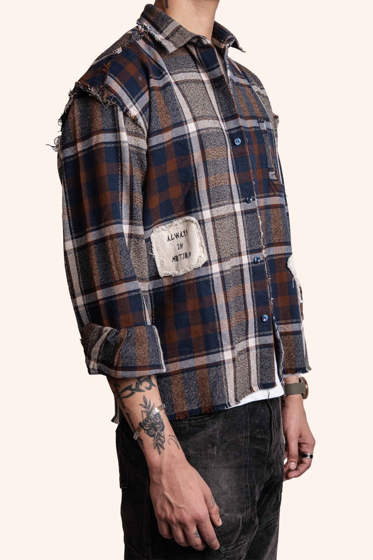 Brown and blue plaid flannel shirt, side view with chest pocket and button tabs