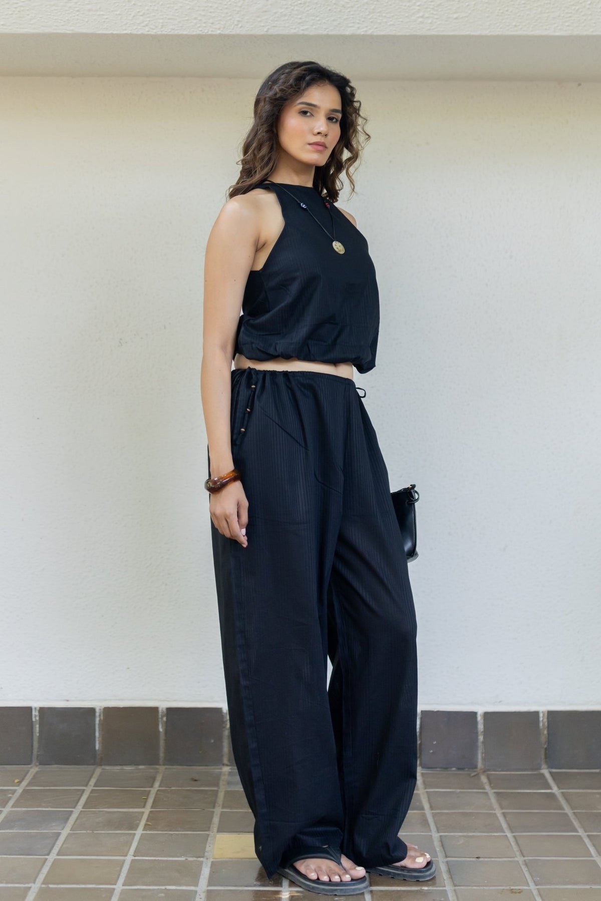 Sleeveless dark top and wide-leg pants co-ord set with tie waist, side view