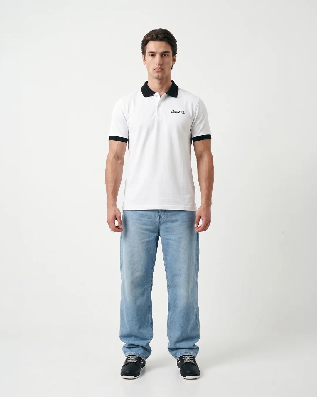 White polo shirt on model, black contrast collar and sleeve cuffs