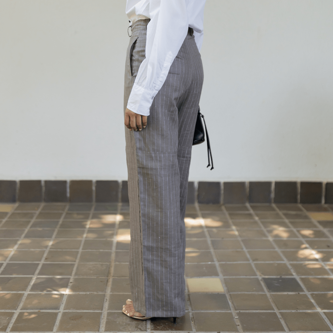 Dark gray pinstripe linen trousers with long wide-leg silhouette and ankle-length hem