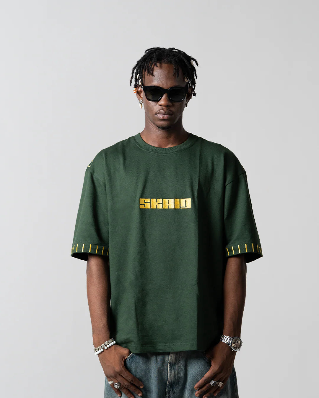 Green graphic T-shirt with yellow SHAWN logo and striped sleeve trim