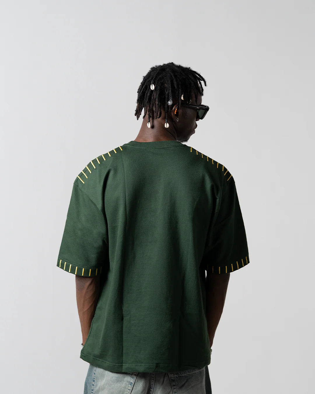 Green graphic T-shirt showing back with yellow striped sleeve trim