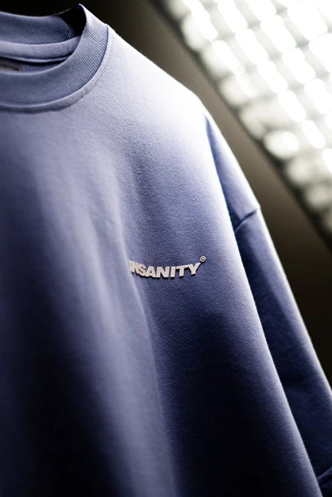 Lavender T-shirt close-up with small 'INSANITY' logo on the chest