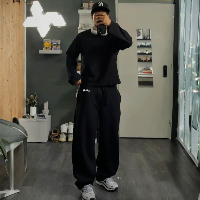 Black sweatpants with drawstring waist and "HARAH" logo on the left thigh.