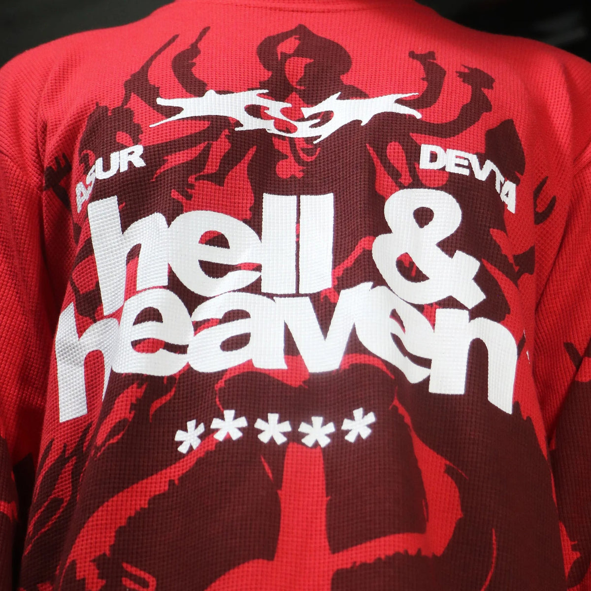 Red long-sleeve waffle knit top with large white “hell & heaven” text and graphic