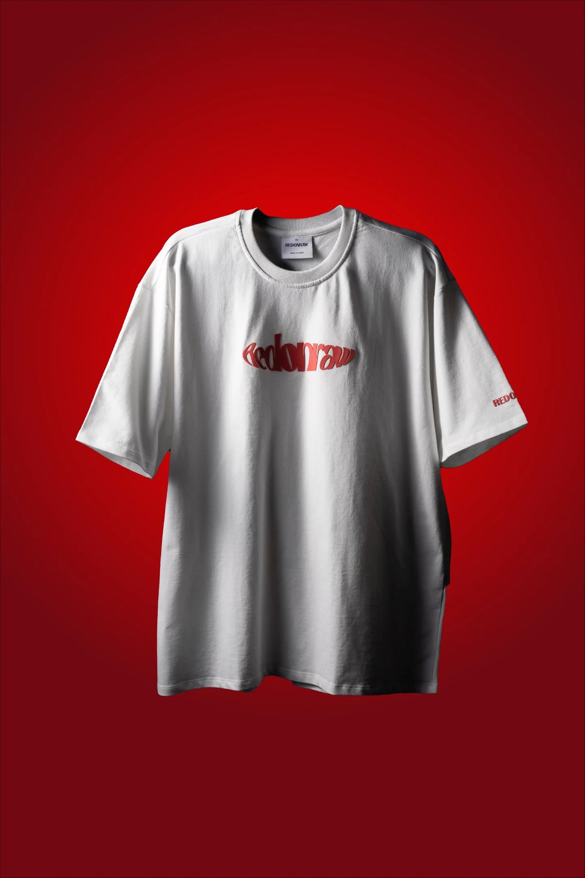 White crew-neck T-shirt with red stylized logo graphic on the chest.