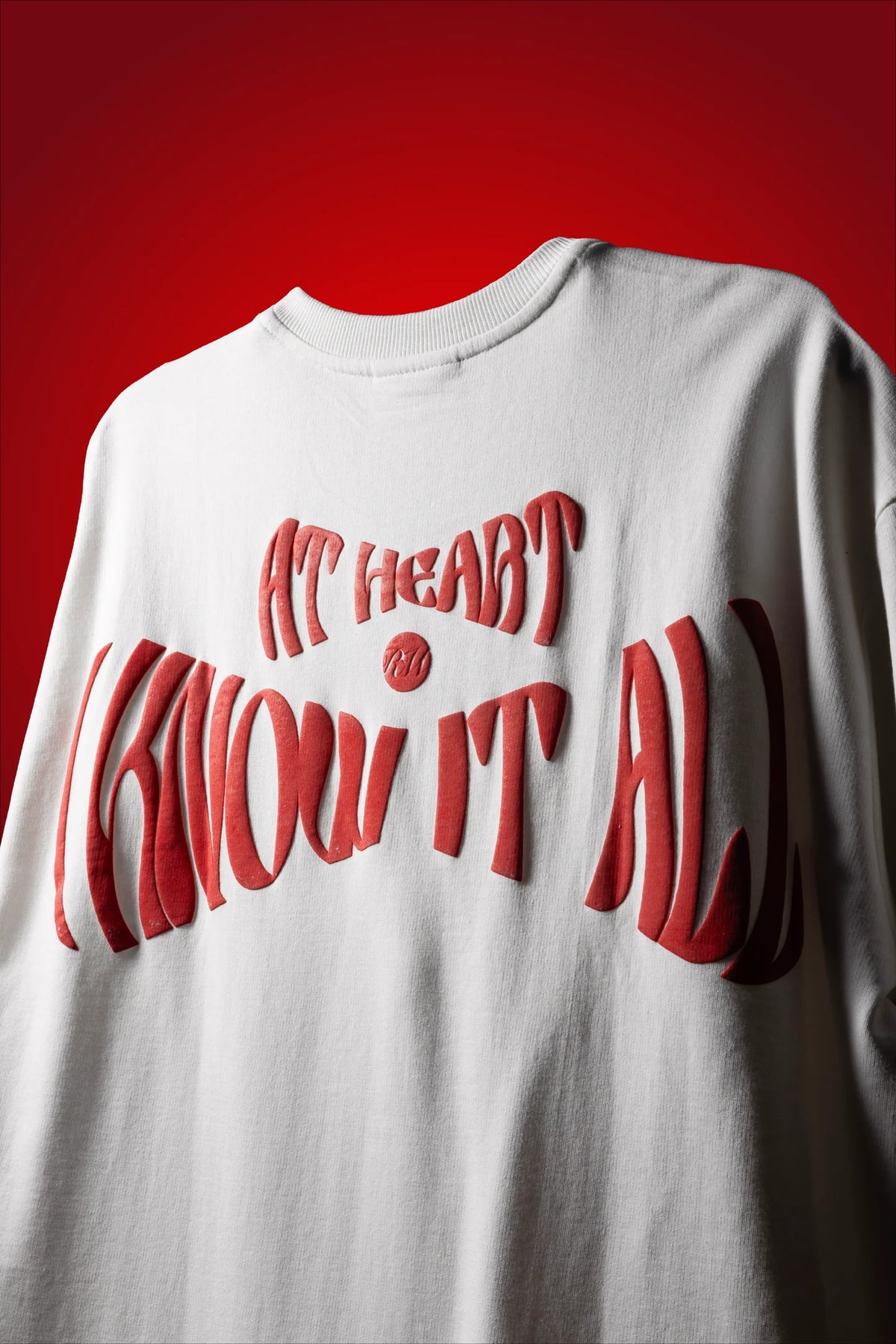 White crew-neck T-shirt with red stylized lettering graphic across the back.