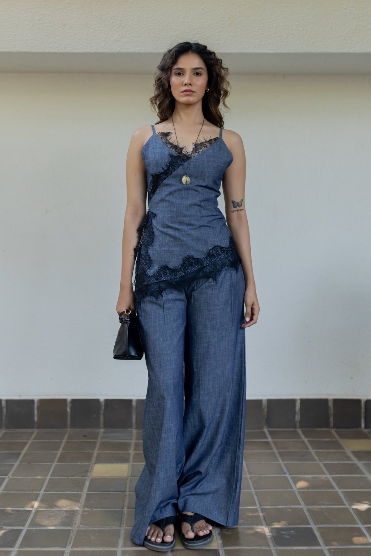 Denim camisole and wide-leg pants with black lace trim and gold necklace charm