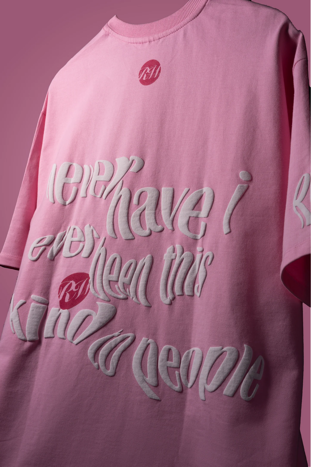 Baby pink T-shirt with large layered back graphic text