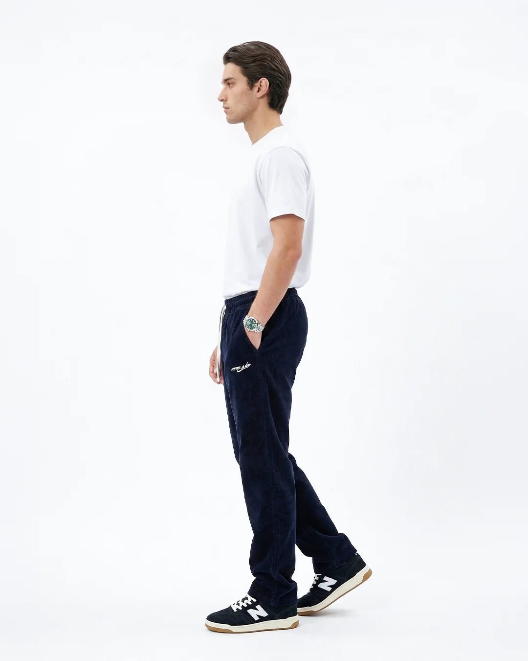 Side view navy corduroy sweatpants with white drawstring and script logo