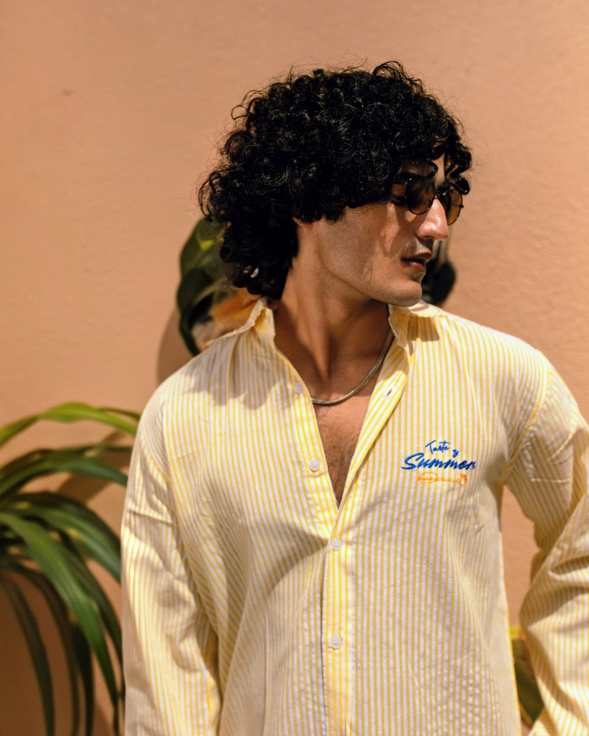 Yellow seersucker striped button-up shirt with pointed collar and chest logo