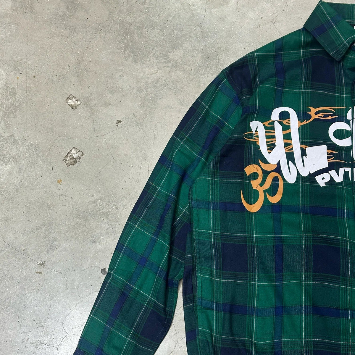 Green plaid button-up shirt side view with large front graphic print