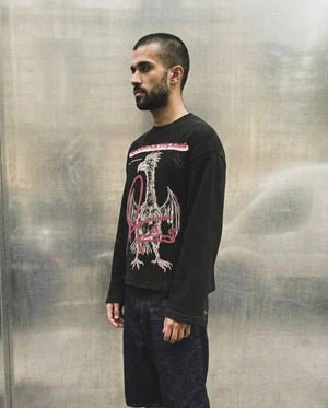 Black long-sleeve T-shirt with pink dragon-style graphic on front, worn