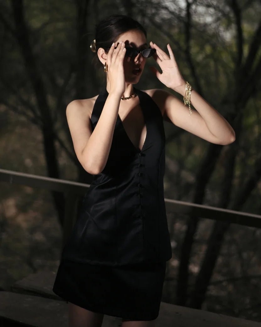Black halter satin mini dress with deep V neckline and button detailing