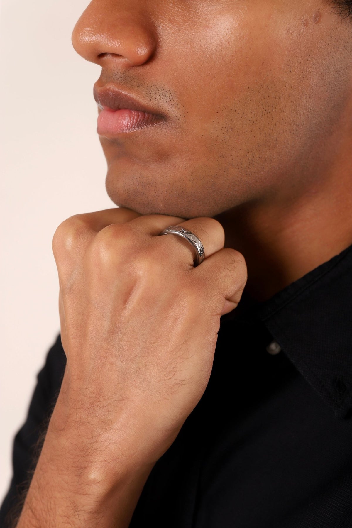 Silver-tone textured ring on finger, visible in side profile