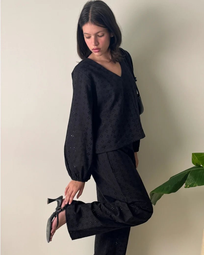 Women's black V-neck blouse with puff sleeves and matching wide-leg trousers