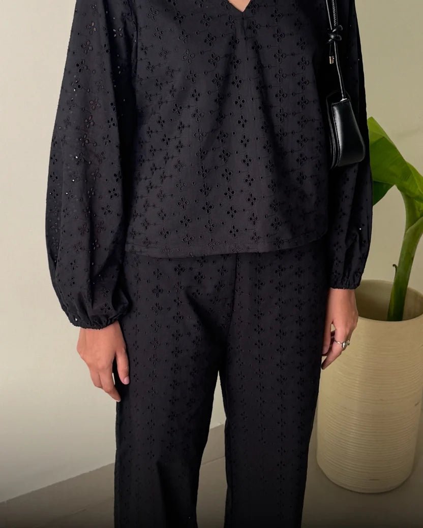 Women's black patterned blouse and wide-leg trousers set, close-up view