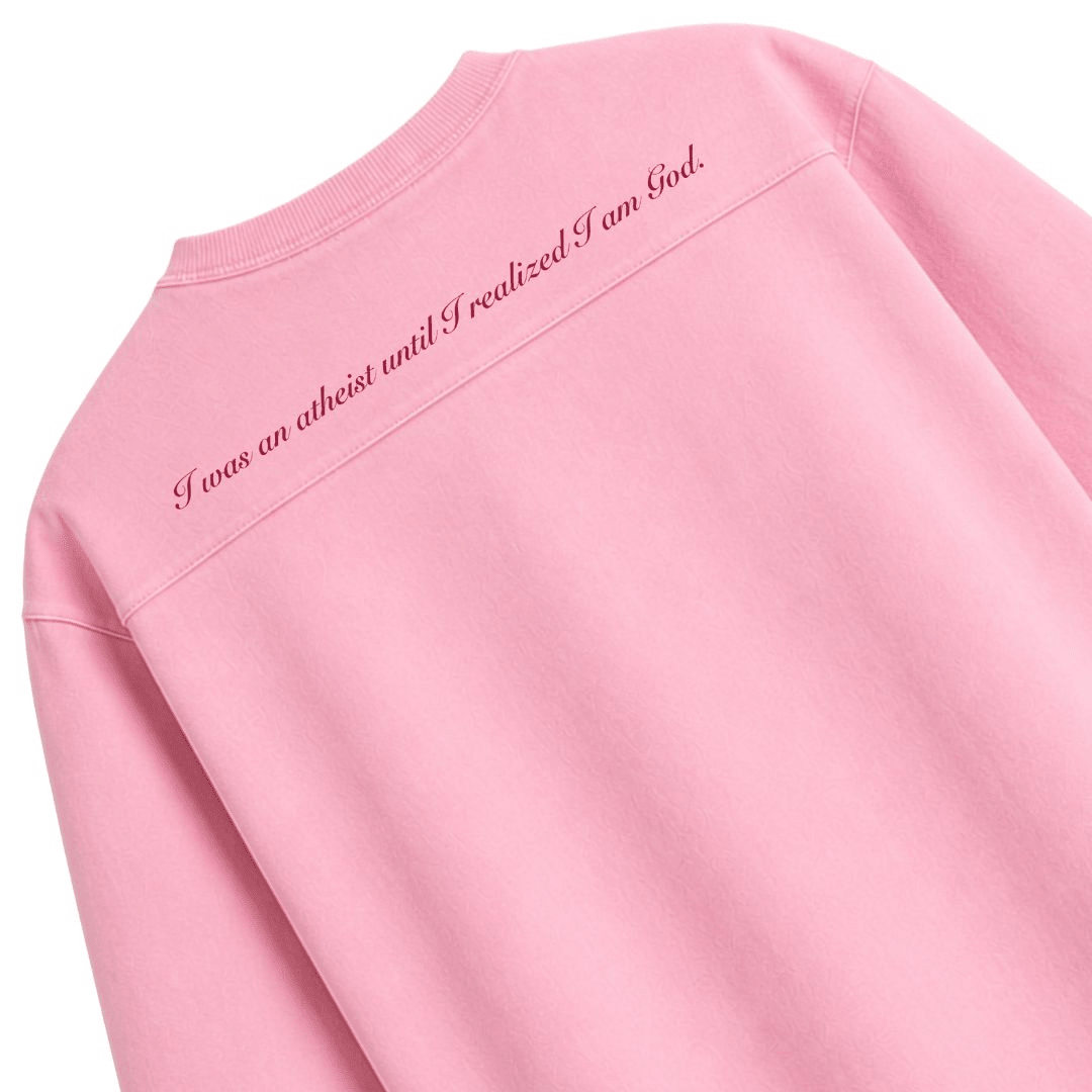Pink oversized boxy rugged t-shirt back text: 'I was an atheist until I am God' (angled)