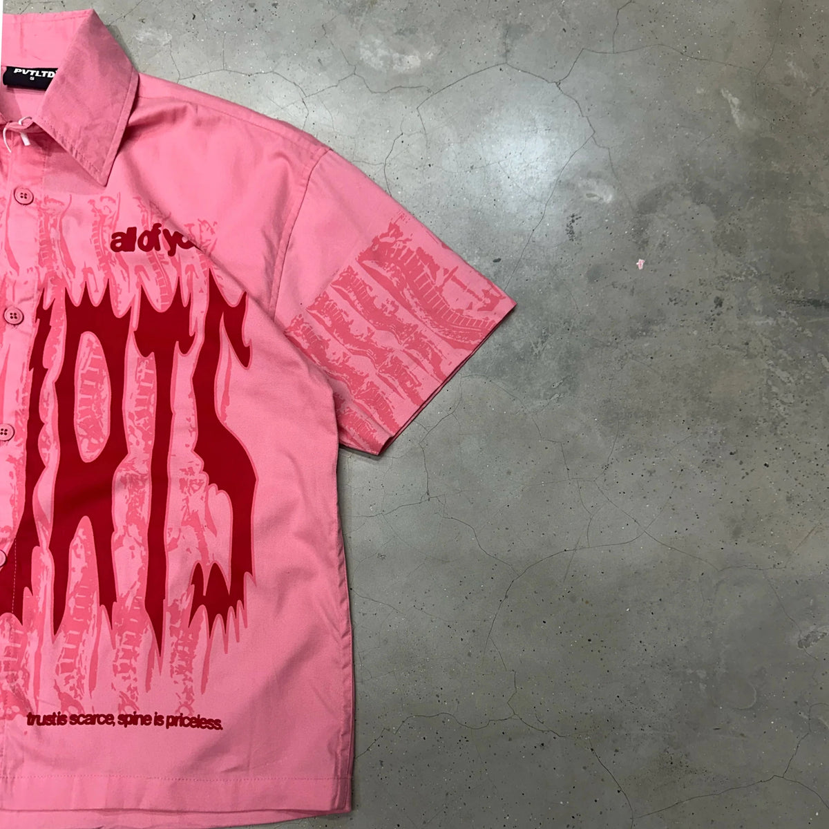 Pink short-sleeve button-up shirt with side sleeve graphic print detail
