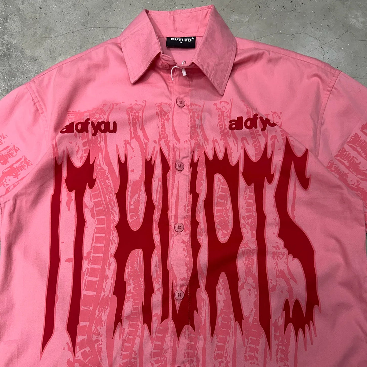 Pink short-sleeve button-up shirt showing drip graphic and button placket