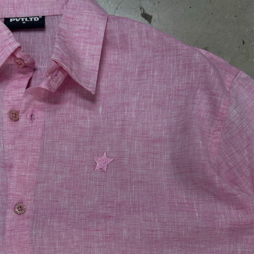 Pink button-up shirt close-up: pointed collar and small star on chest