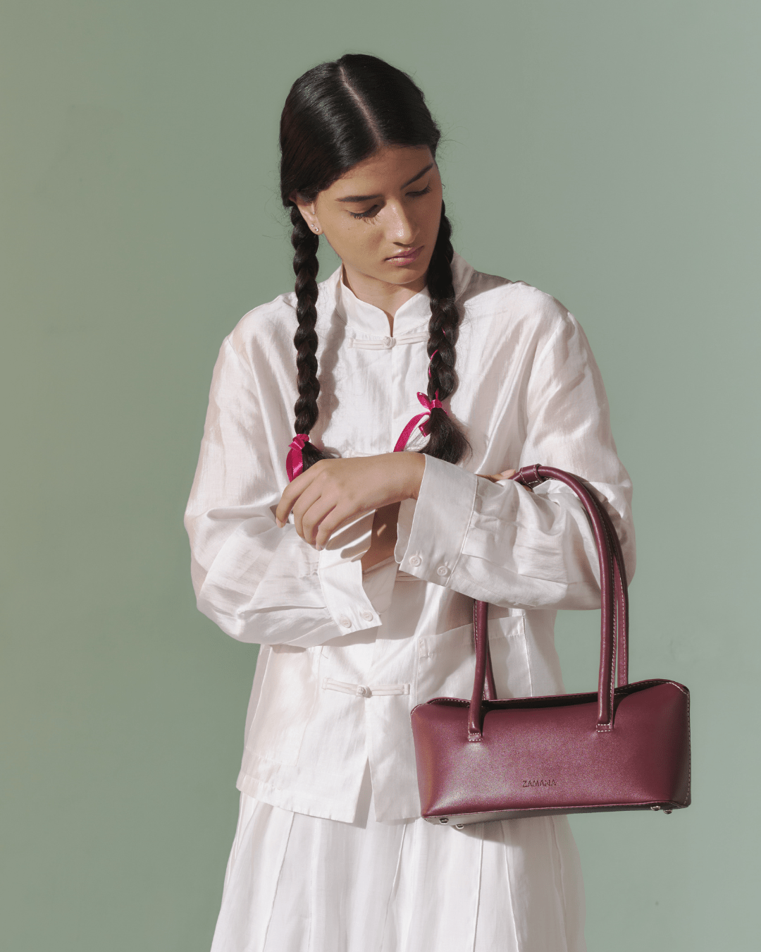 Burgundy leather-look top-handle bag with long straps on a standing model