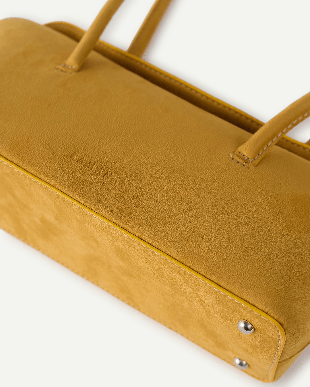 Mustard yellow suede tote bag corner with snap button closure and stitching