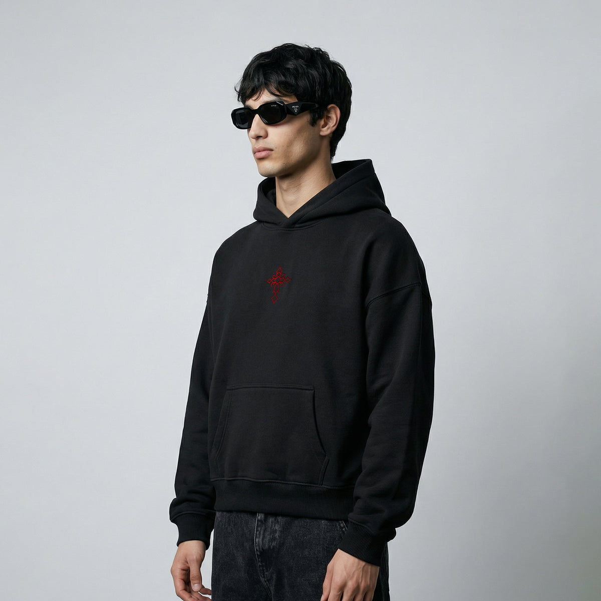 Black pullover hoodie with red chest graphic and front pocket