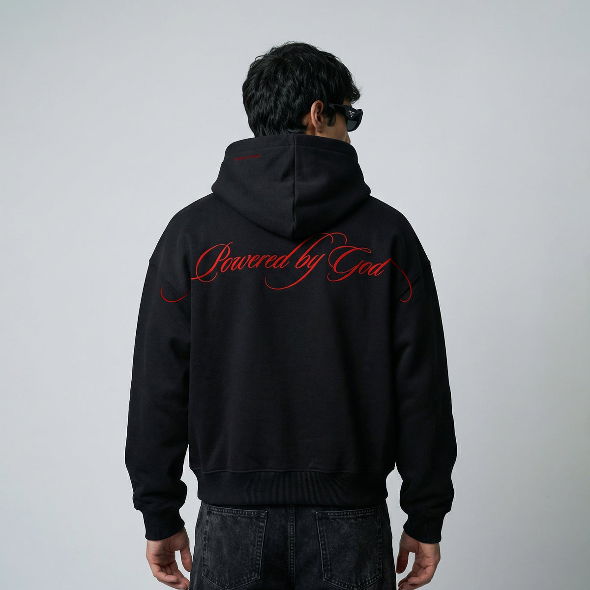 Black pullover hoodie, red "Powered by God" back graphic