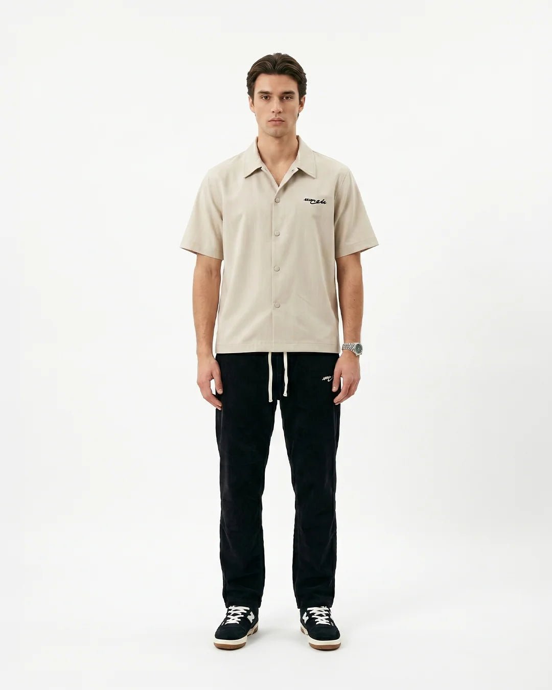 Beige linen short-sleeve button-up shirt with chest logo and button front