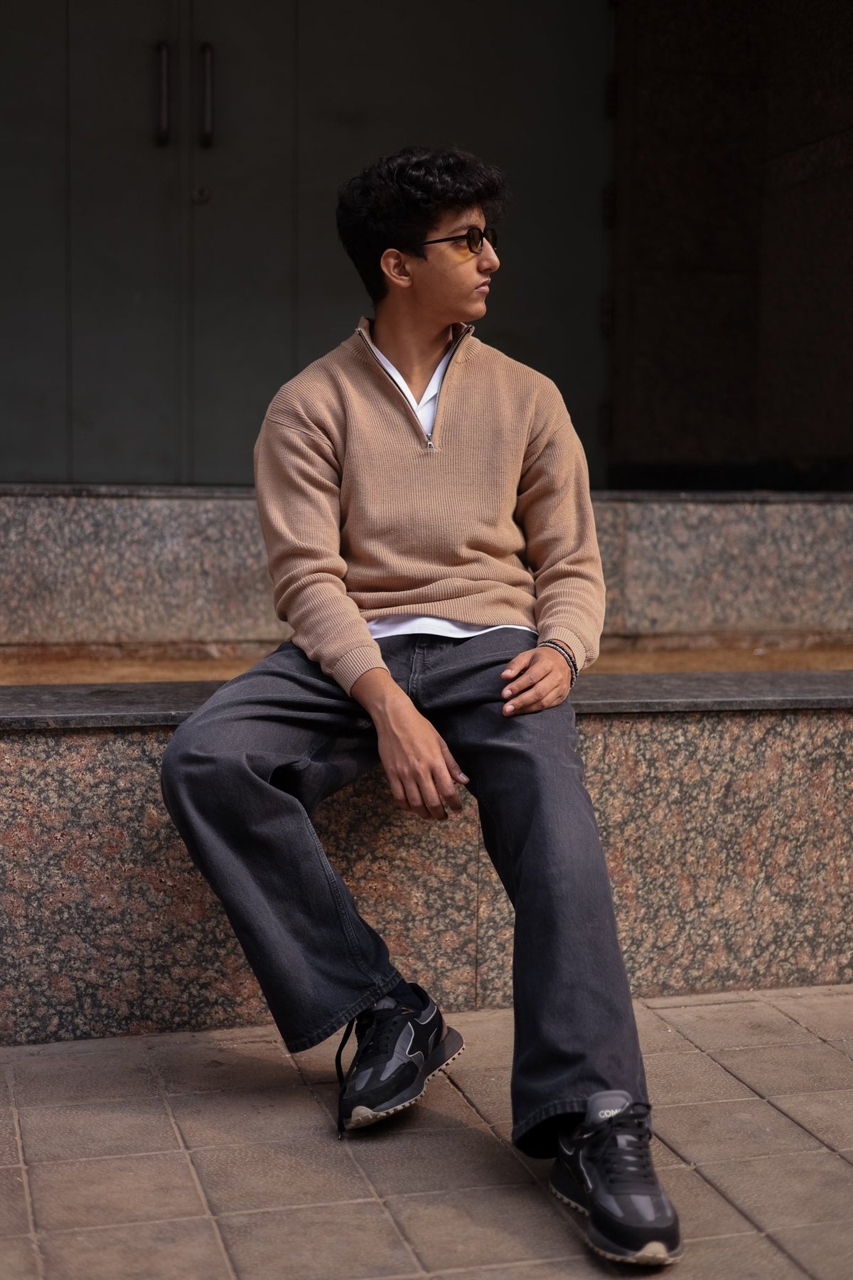 Beige knit quarter-zip sweater with long sleeves and ribbed cuffs