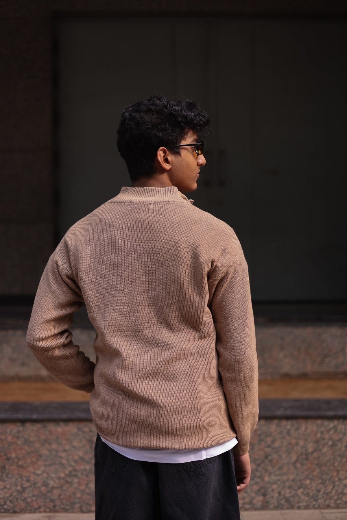 Beige knit quarter-zip sweater, back view with ribbed cuffs