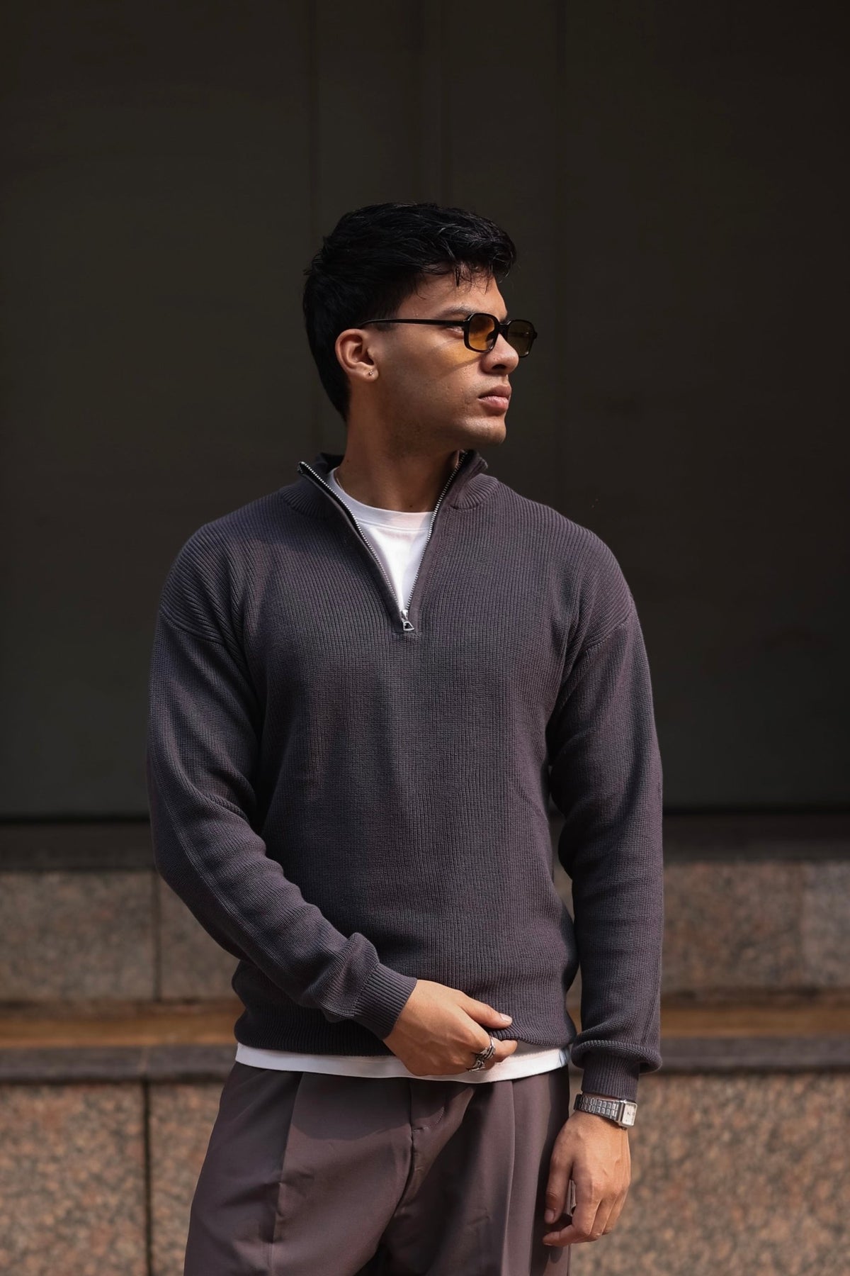 Charcoal quarter-zip knit sweater with ribbed collar and cuffs, worn over a white tee.